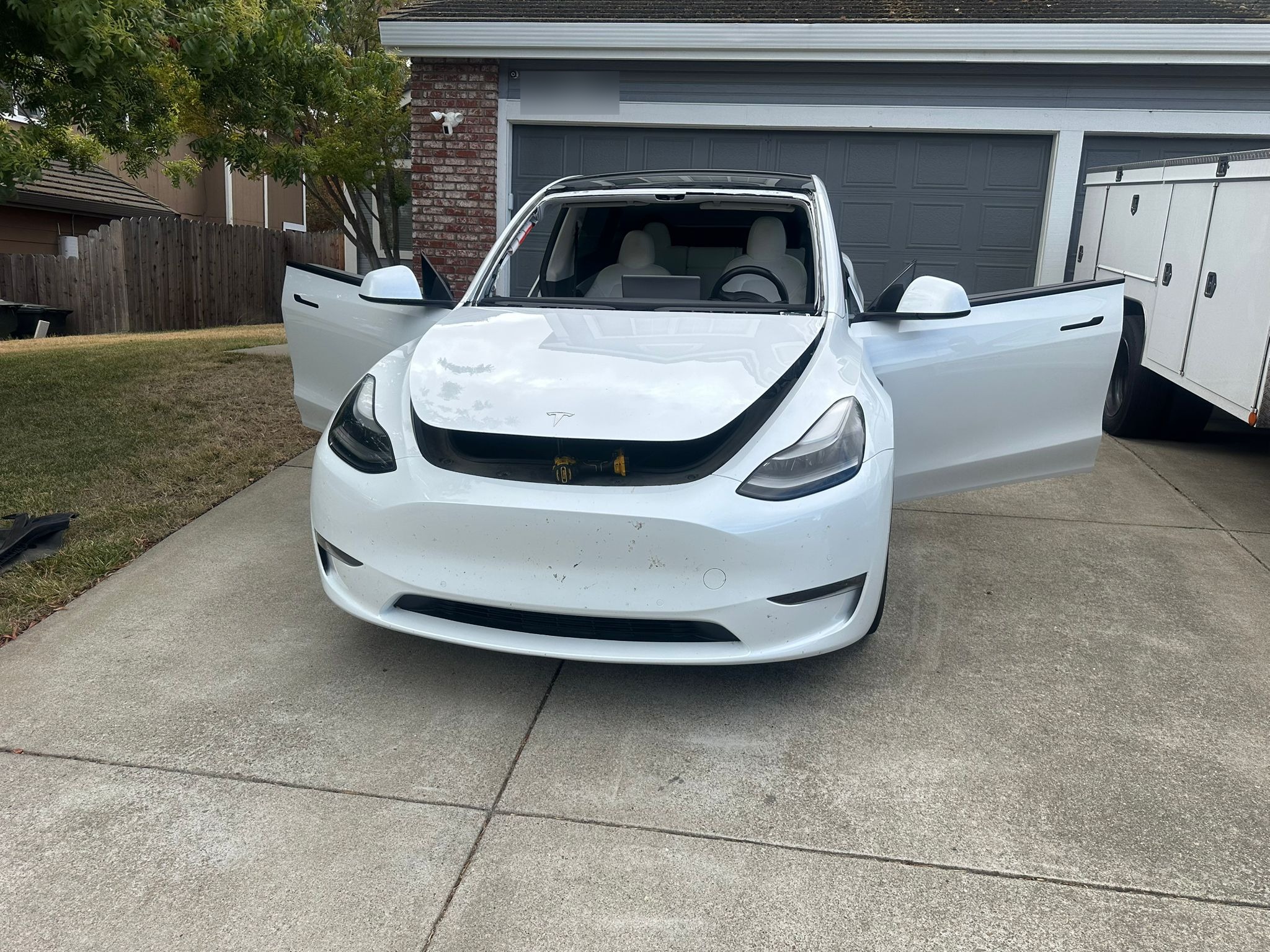 White Tesla Model Y in a Tustin driveway during Auto Glass of OC mobile windshield service